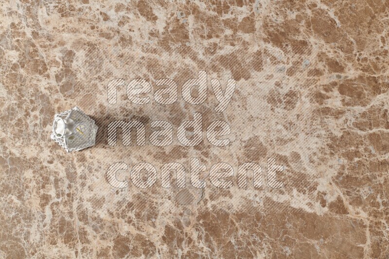 A candle lantern on beige marble background