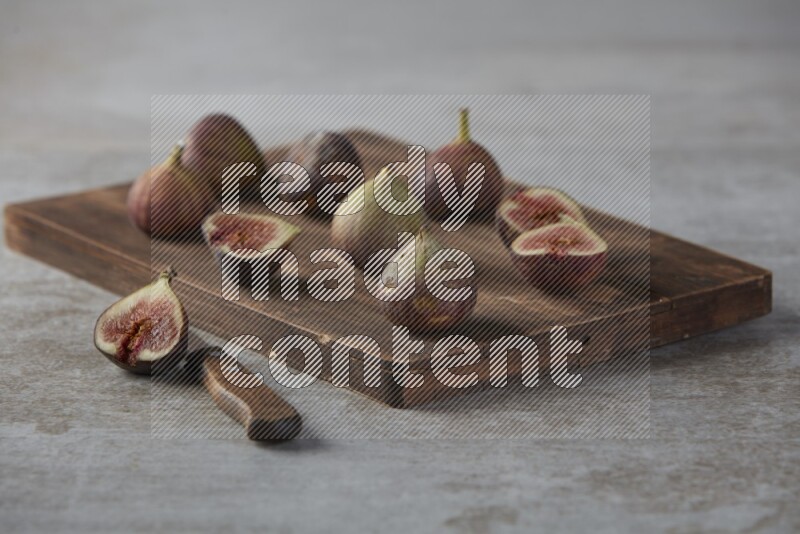 Fresh Figs on a wooden board on a textured grey background