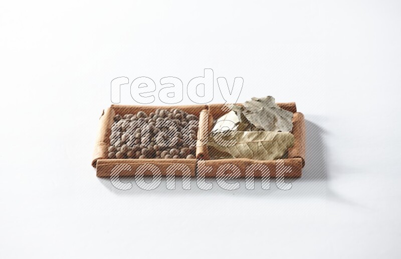 2 squares of cinnamon sticks full of allspice and bay laurel leaves on white flooring