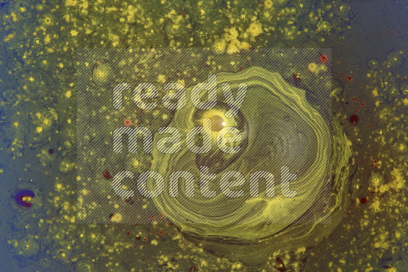 The image captures a dramatic splatter of yellow and red paints over an blue backdrop