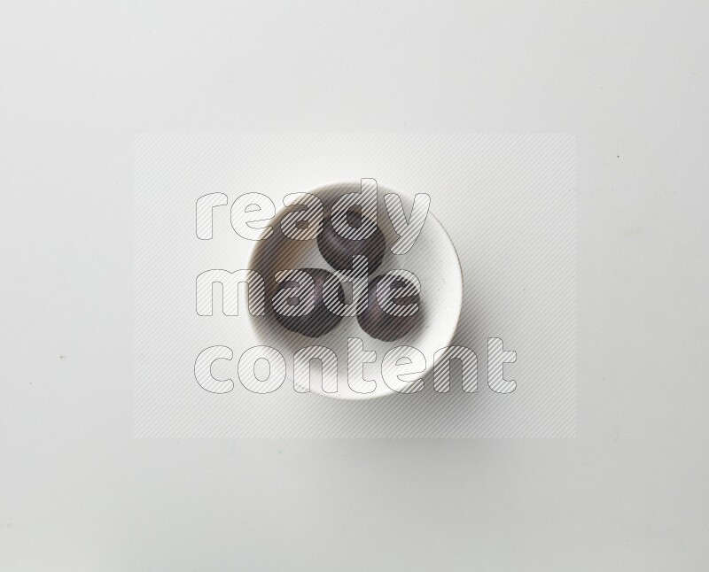Top-view shot of dried lime (loomi) in a container on white background