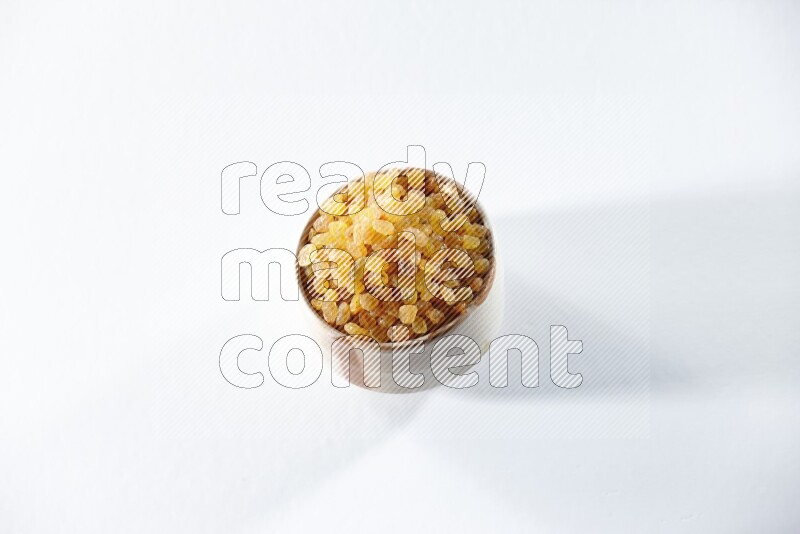 A beige ceramic bowl full of raisins on a white background in different angles