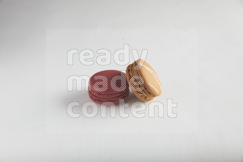 45º Shot of of two assorted Brown Irish Cream, and Red Velvet macarons on white background