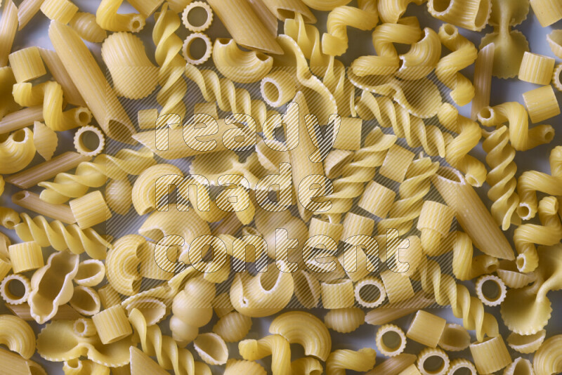 Different pasta types on light blue background