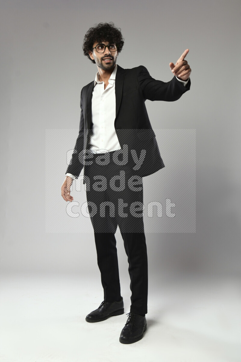 رجل يرتدي ملابس رسمية يقوم بإشارات باليد علي خلفية بيضاء