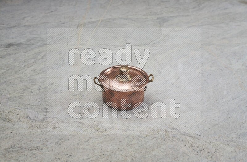 A small copper pot on grey marble background