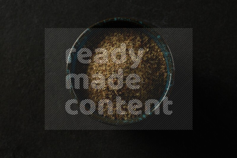 multi color round sauce bowl filled with herbs on grey textured countertop