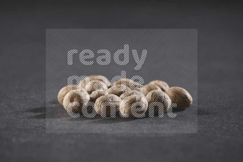 A bunch of whole nutmeg seeds on a black flooring