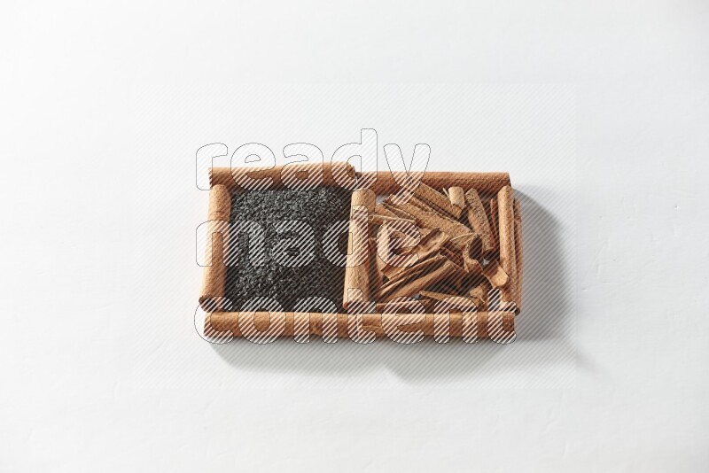 2 squares of cinnamon sticks full of black seeds and cinnamon on white flooring