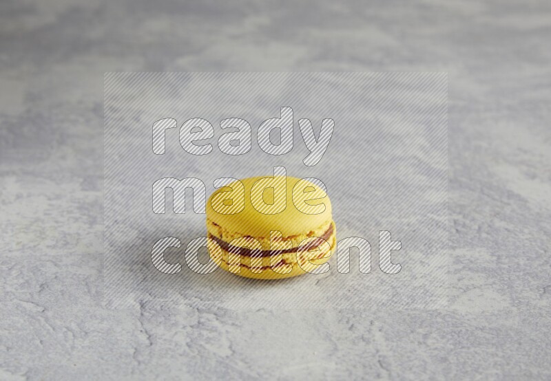 45º Shot of Yellow Lemon macaron on white  marble background