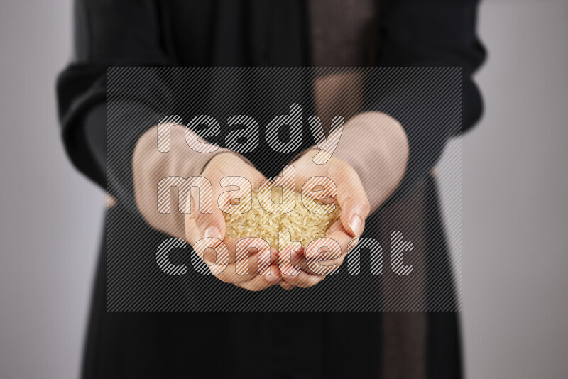 Woman in abaya holding different kinds of legumes in different positions