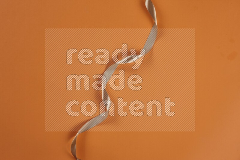 مجموعة من أدوات الخياطة والتفصيل بنية اللون على خلفية برتقالية