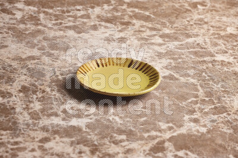 A multicolored pottery plate on beige marble background