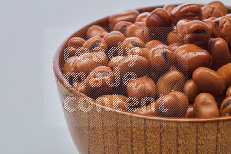 Close up shot of cooked fava beans (foul) in a container on white background