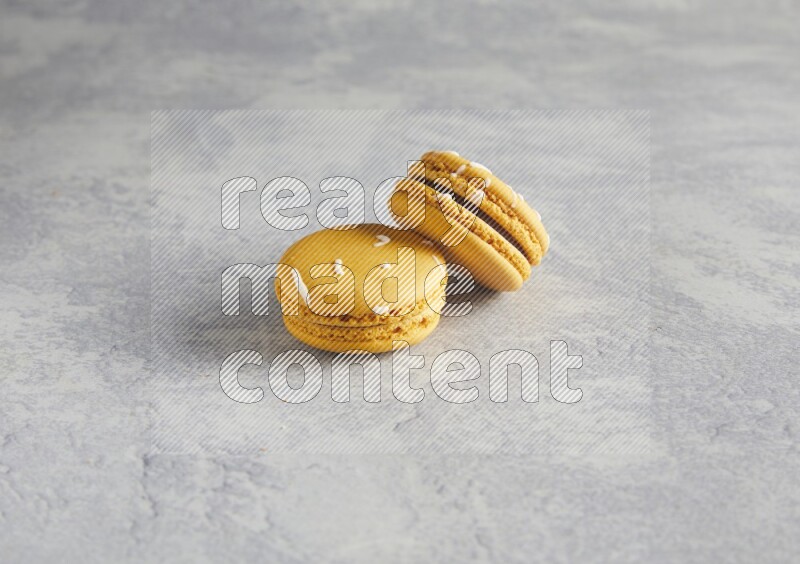 45º Shot of two Yellow Piña Colada macarons  on white  marble background