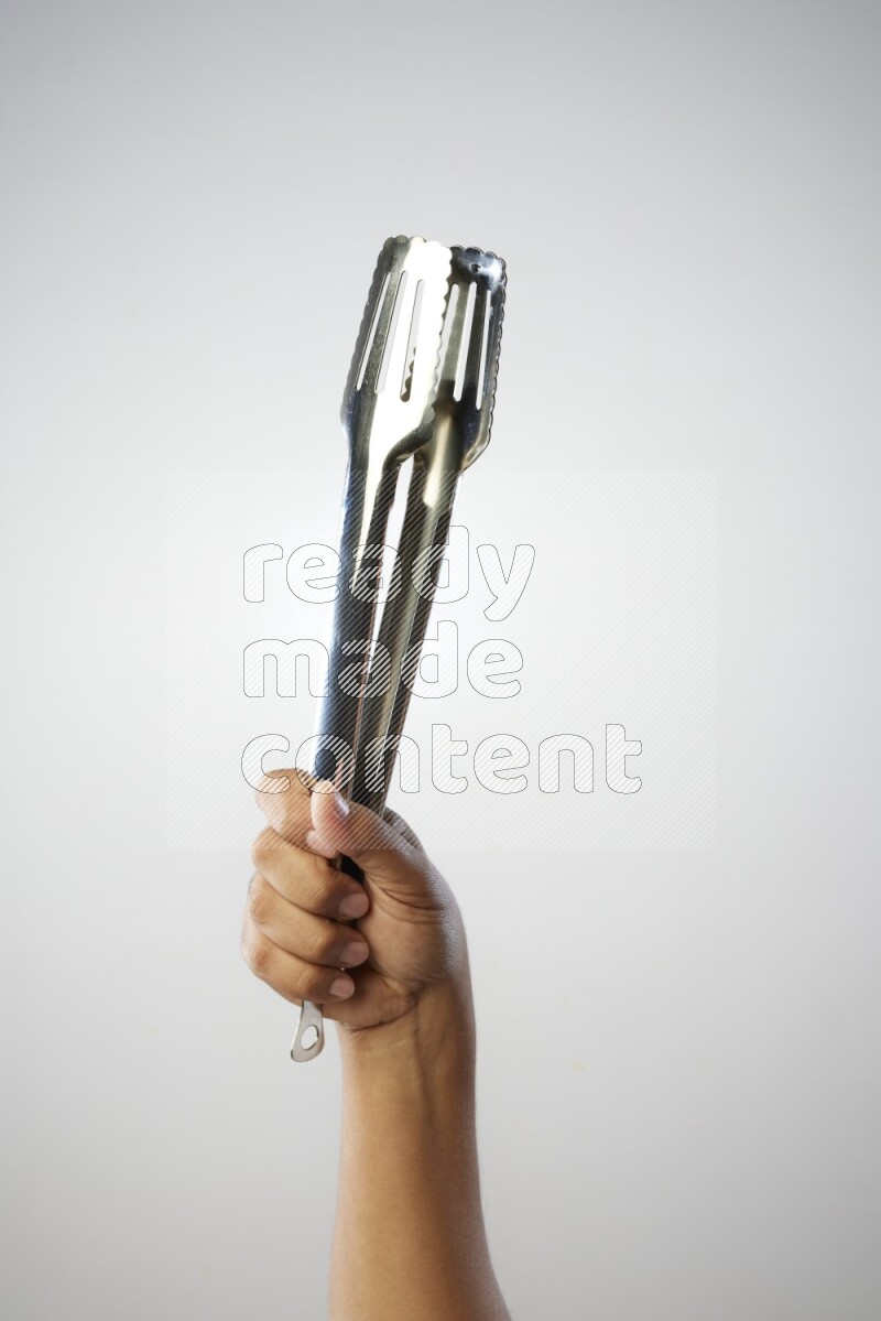 Male Hand Holding Tongs on white background