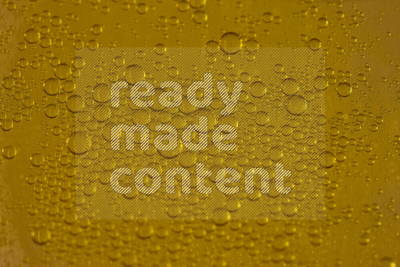 لقطات مقربة لقطرات من الماء على سطح الزيت على خلفية صفراء