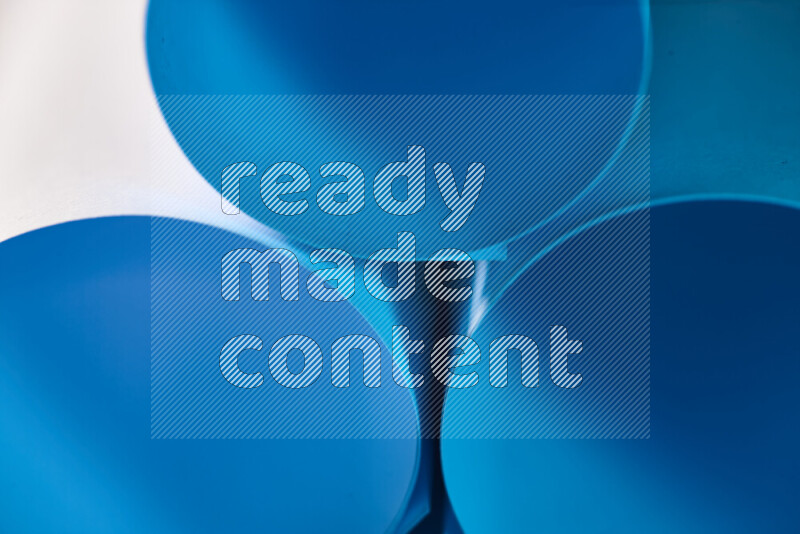 The image shows an abstract paper art with circular shapes in varying shades of blue