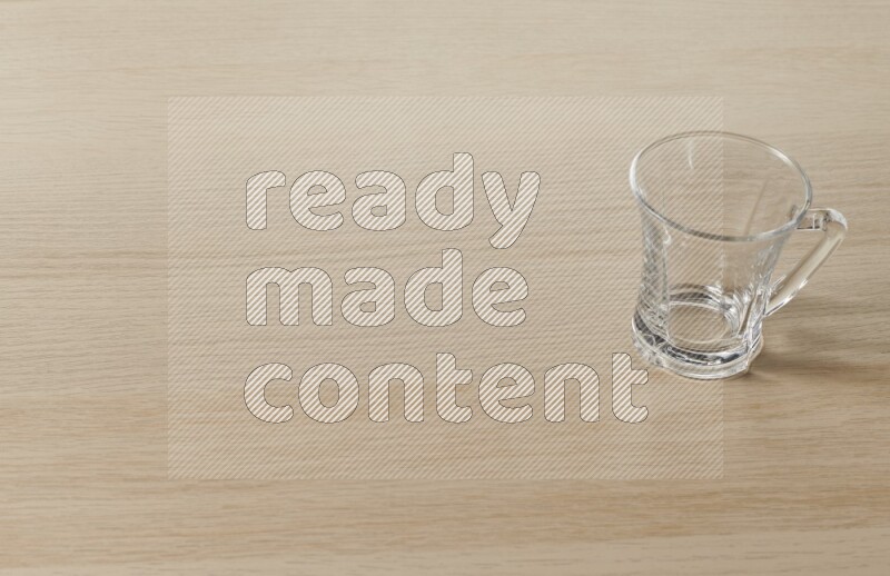 An empty glass cup on light wooden background