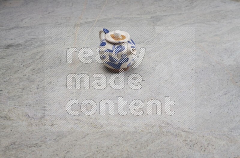 A pottery teapot on grey marble background