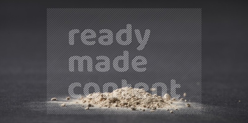 كومة صغيرة من بودرة الثوم على خلفية سوداء