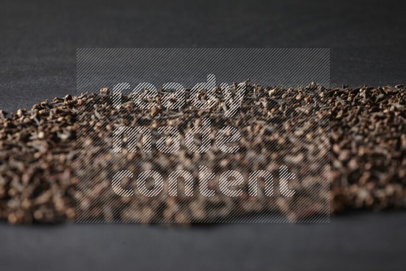 Cloves spread on black flooring