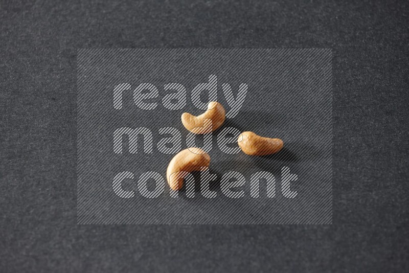 3 cashews on a black background in different angles