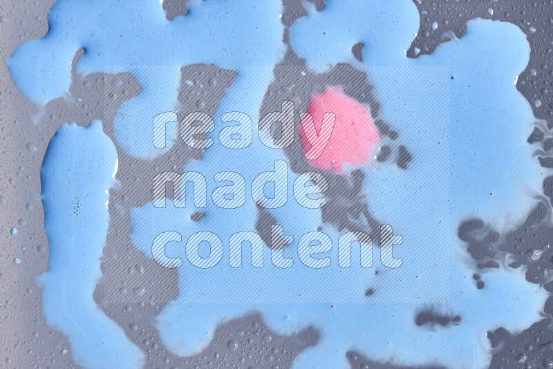 Close-ups of abstract pink and blue paint droplets on the surface