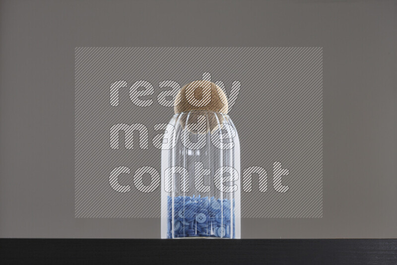 Buttons in a glass jar on black background