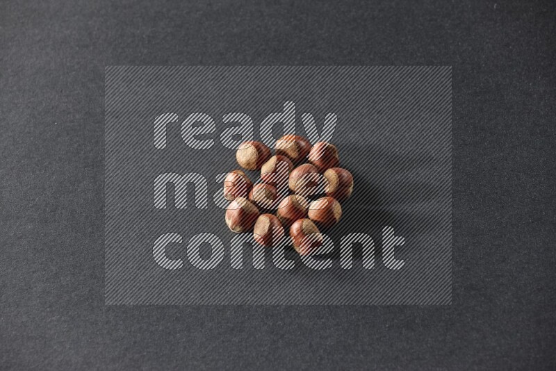 A bunch of hazelnuts on a black background in different angles