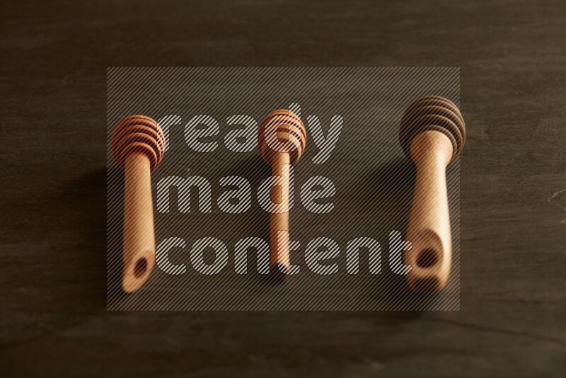 Wooden honey dipper on black slate background