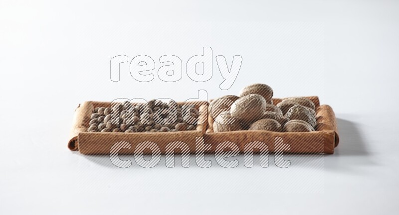 2 squares of cinnamon sticks full of allspice and nutmegs on white flooring