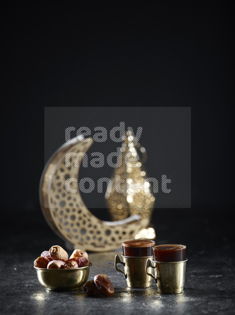 تمر مع مشروبات ساخنة وفوانيس ذهبية علي خلفية سوداء خشبية