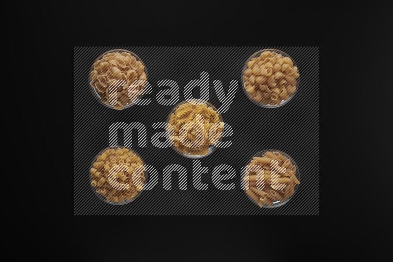 أنواع مختلفة من المعكرونة في أوعية زجاجية علي خلفية سوداء