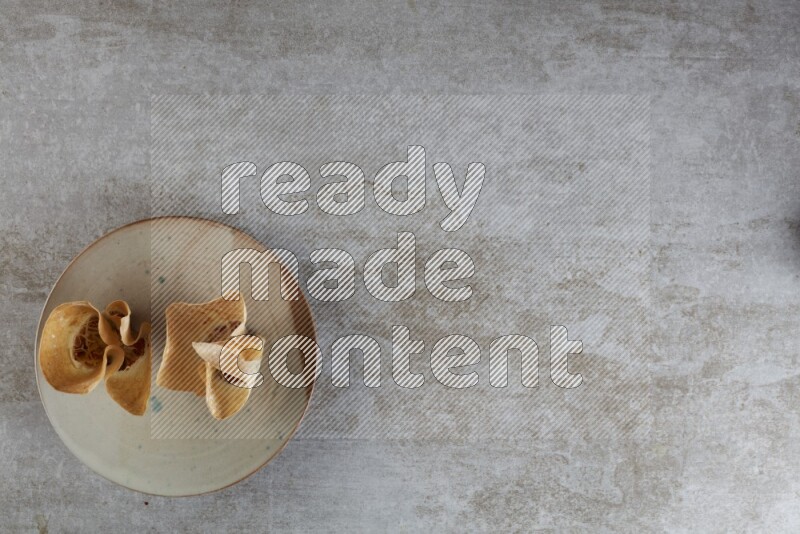 wonton cups with soy sauce ramkin on multi colored pottery on grey textured counter top