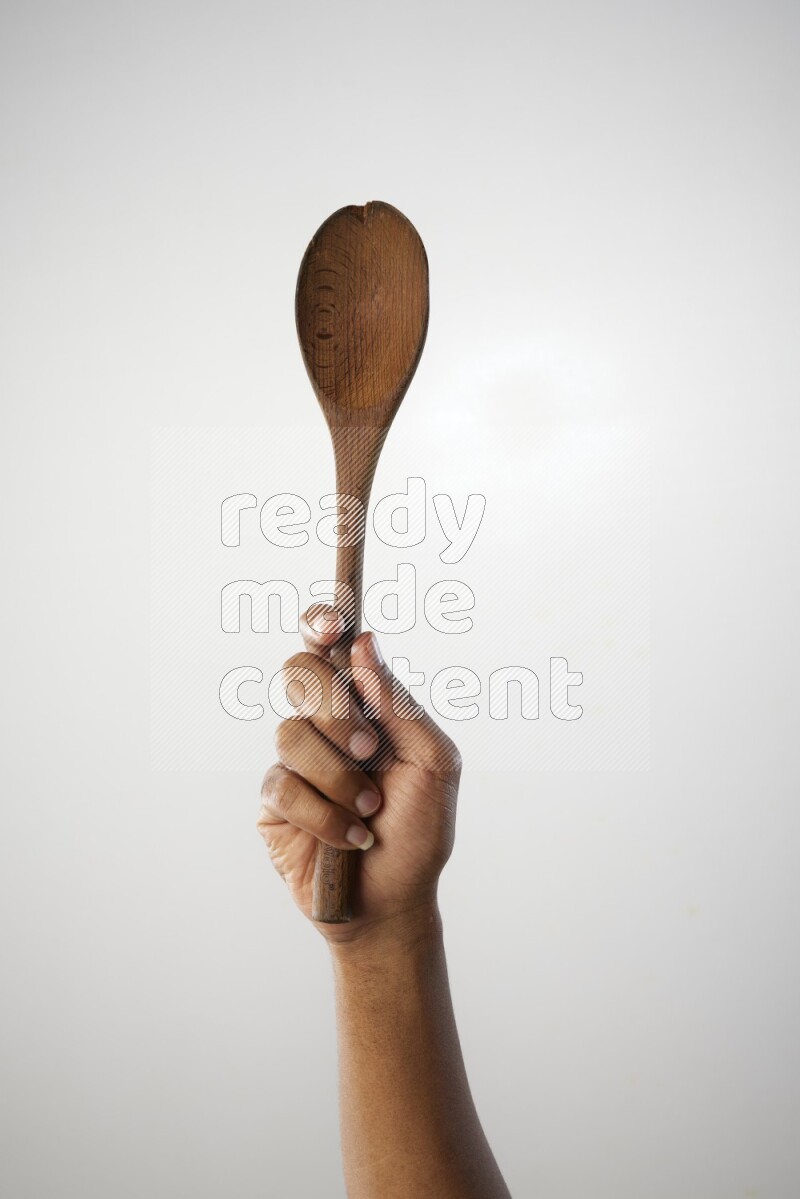 Male Hand Holding Wooden spoon on white background