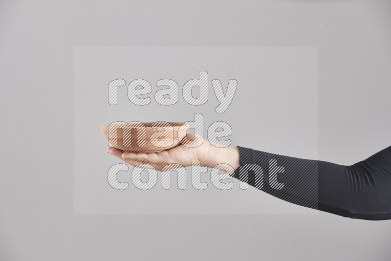 امرأة ترتدي عباءة سوداء تحمل أدوات خشبية مختلفة في أوضاع متعددة