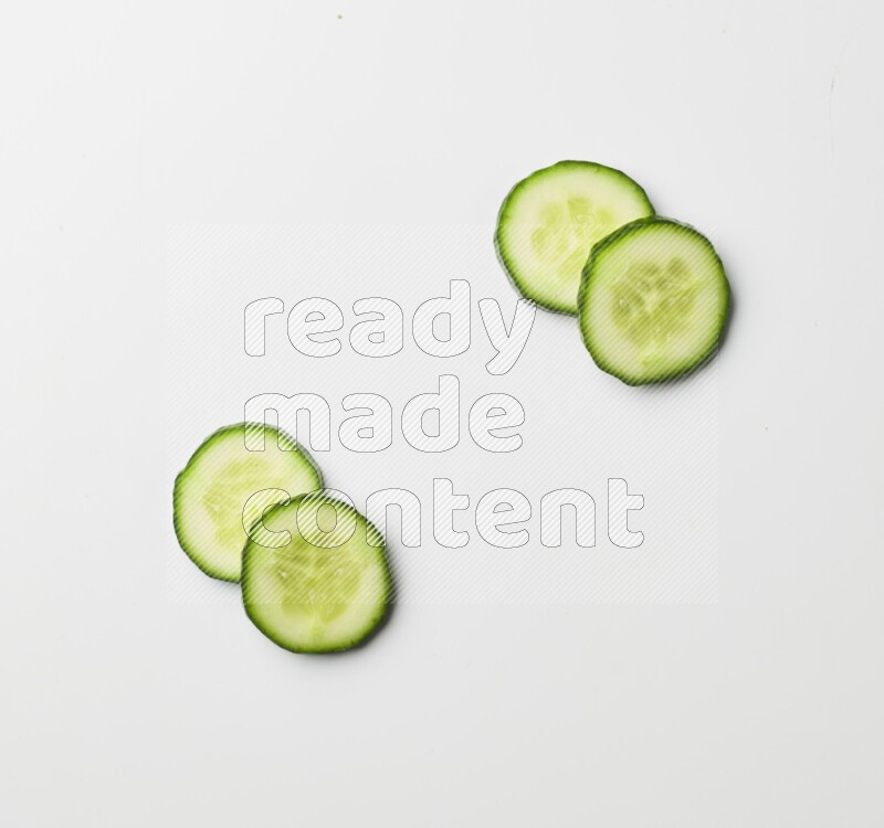 Multiple cucumber slices on white background
