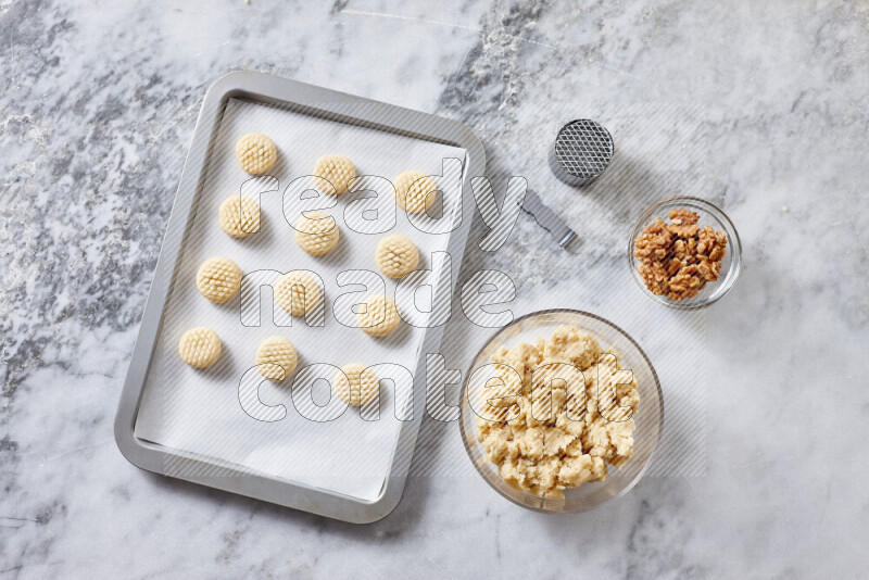 Kahk step by step with its ingredients ghee, sugar, flour, sesame, yeast, water and kahk flavor on grey marble background