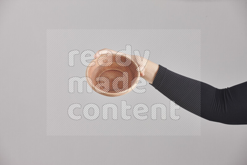 امرأة ترتدي عباءة سوداء تحمل أدوات خشبية مختلفة في أوضاع متعددة