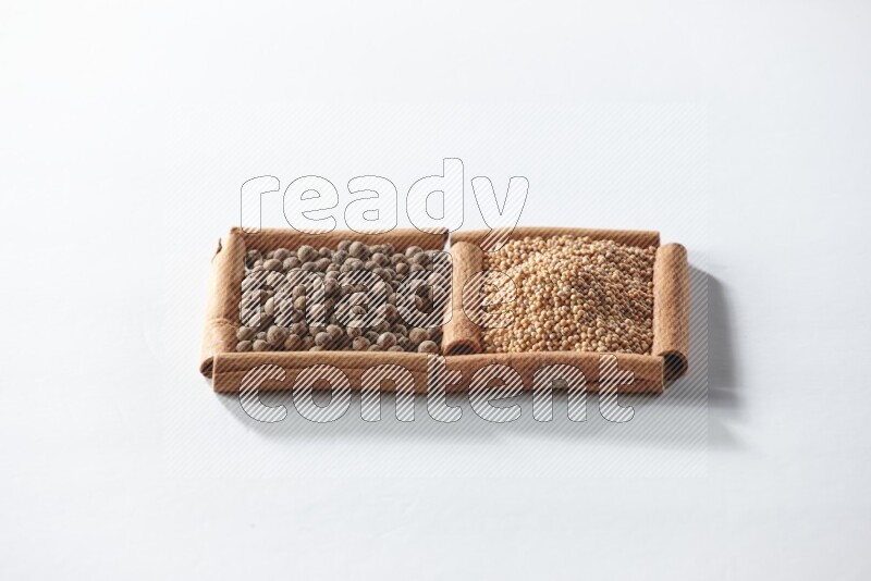 2 squares of cinnamon sticks full of mustard seeds and allspice on white flooring
