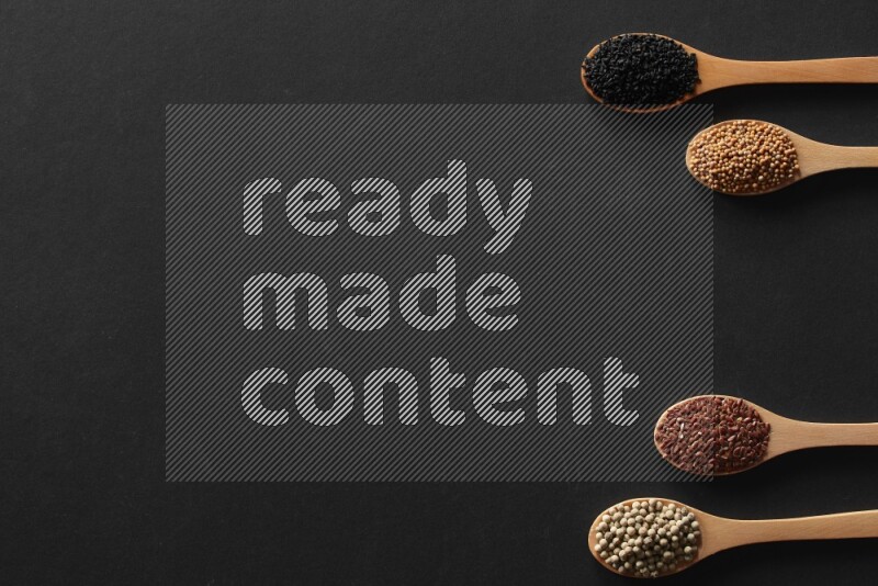 الفلفل الأسود وحبوب الخردل وحبة البركة وحب الرشاد والكمون و حبوب الكتان في معالق خشبية علي خلفية سوداء