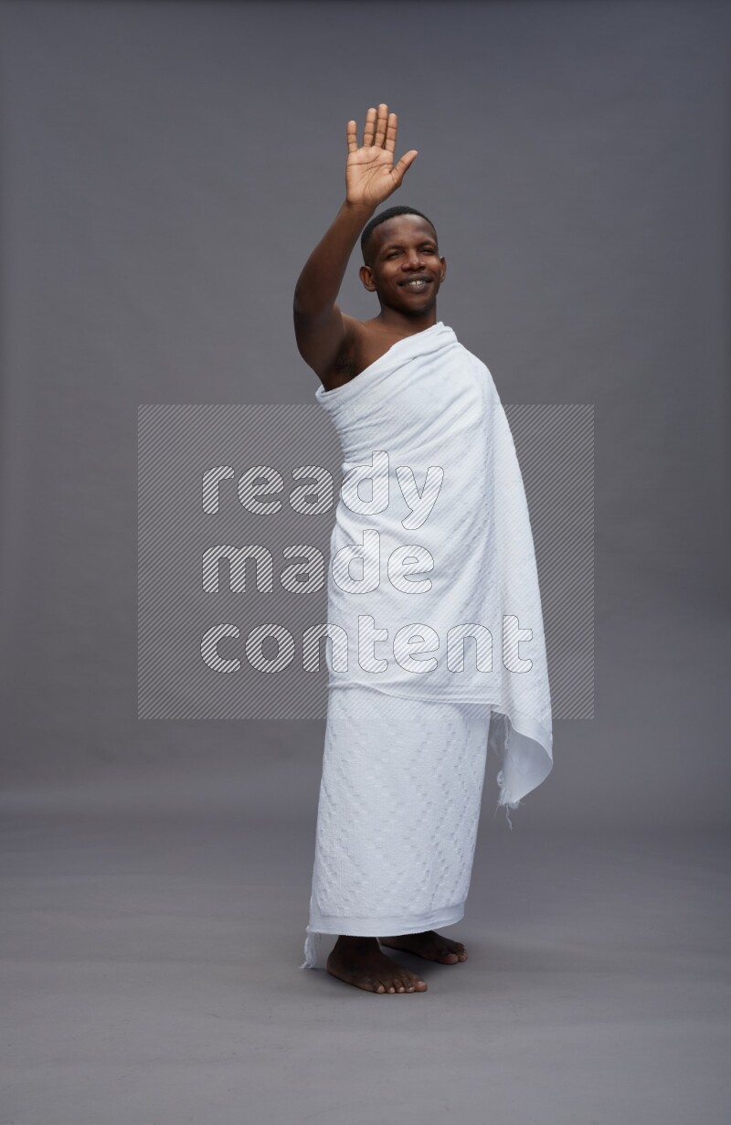 A man wearing Ehram Standing Interacting with the camera on gray background