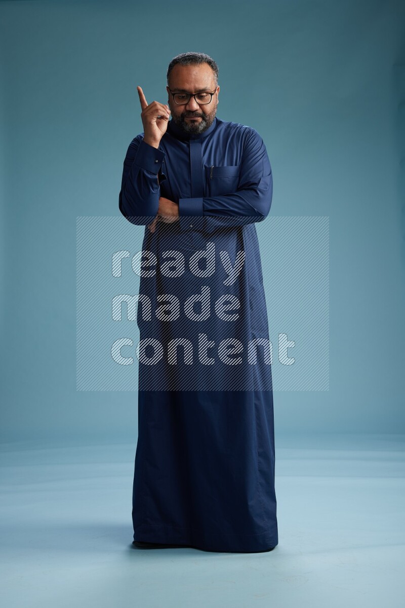 Saudi Man without shimag Standing Interacting with the camera on blue background