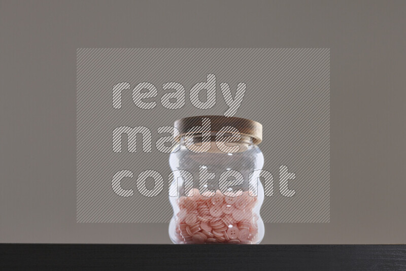 Buttons in a glass jar on black background