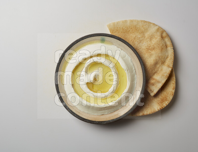 Lebnah garnished with olive oil in a pottery plate on a white background