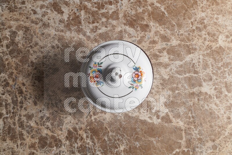 A vintage metal pot on beige marble background