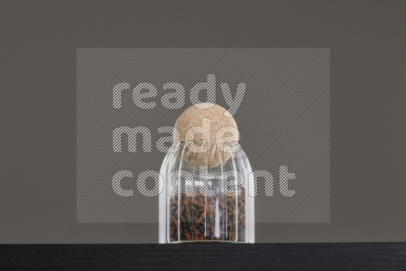 Star anise in a glass jar on black background
