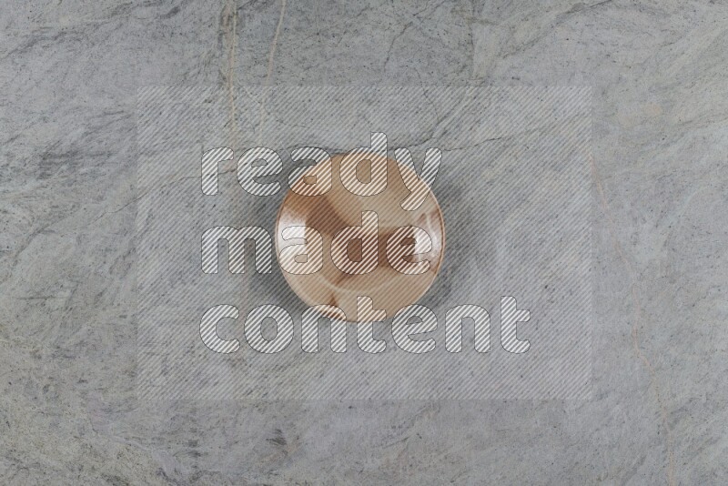 A multicolored pottery plate on grey marble background