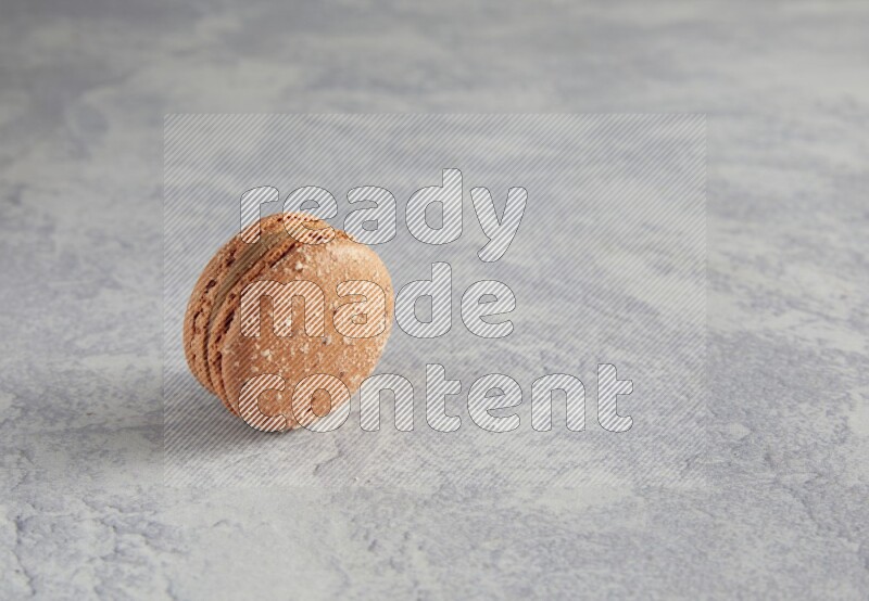 45º Shot of Brown Hazelnuts macaron on white  marble background